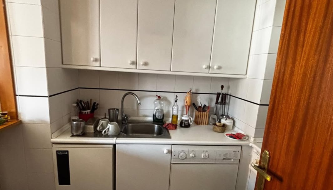 Interior moderno con mesa, sillas, y decoración en microcemento claro mate.