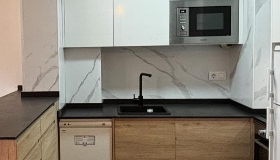 Interior moderno con mesa, sillas, y decoración en microcemento claro mate.