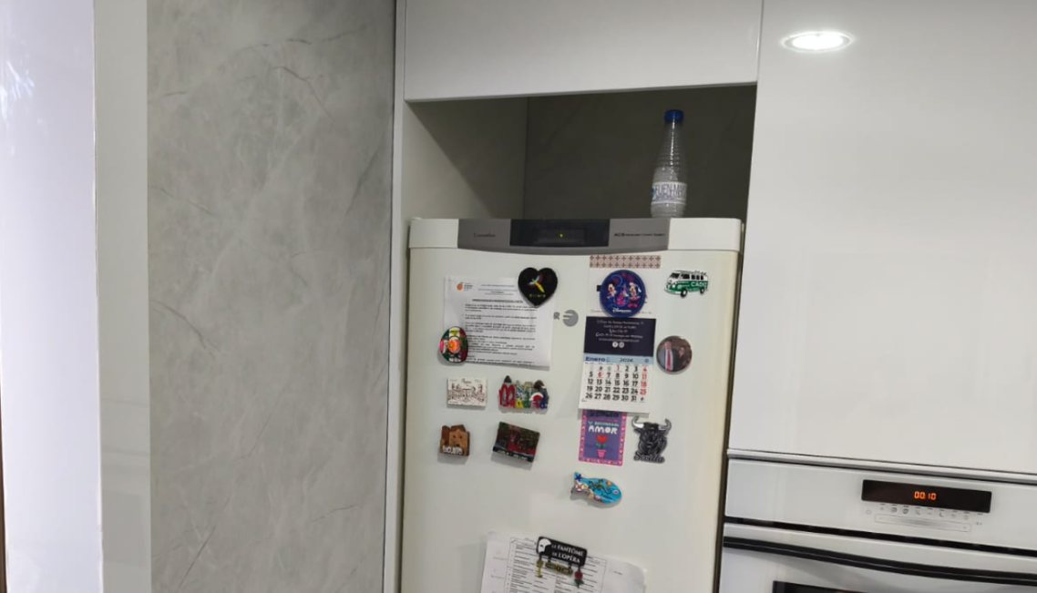 Baño con pared desgastada y texturizada, con detalles decorativos.