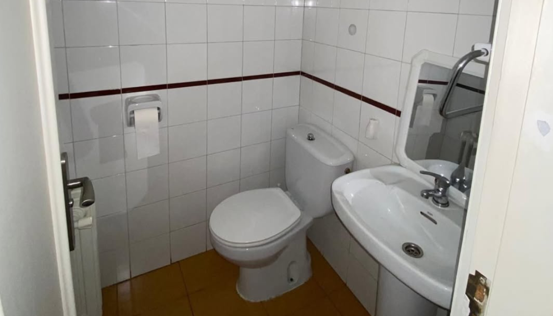 Interior moderno con mesa, sillas, y decoración en microcemento claro mate.