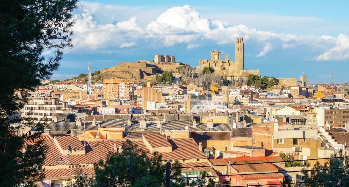 Vista panorámica de Lleida con un castillo en la cima de una colina.