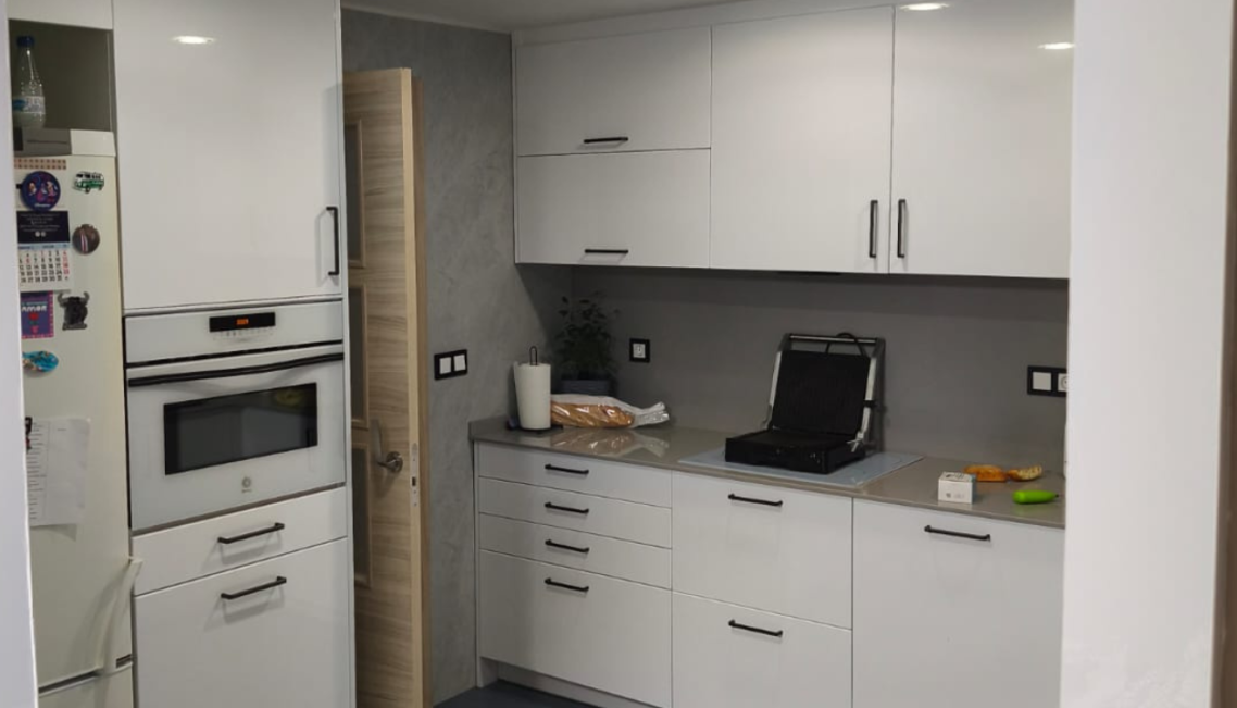 Baño moderno con paredes de piedra gris mate y accesorios minimalistas.